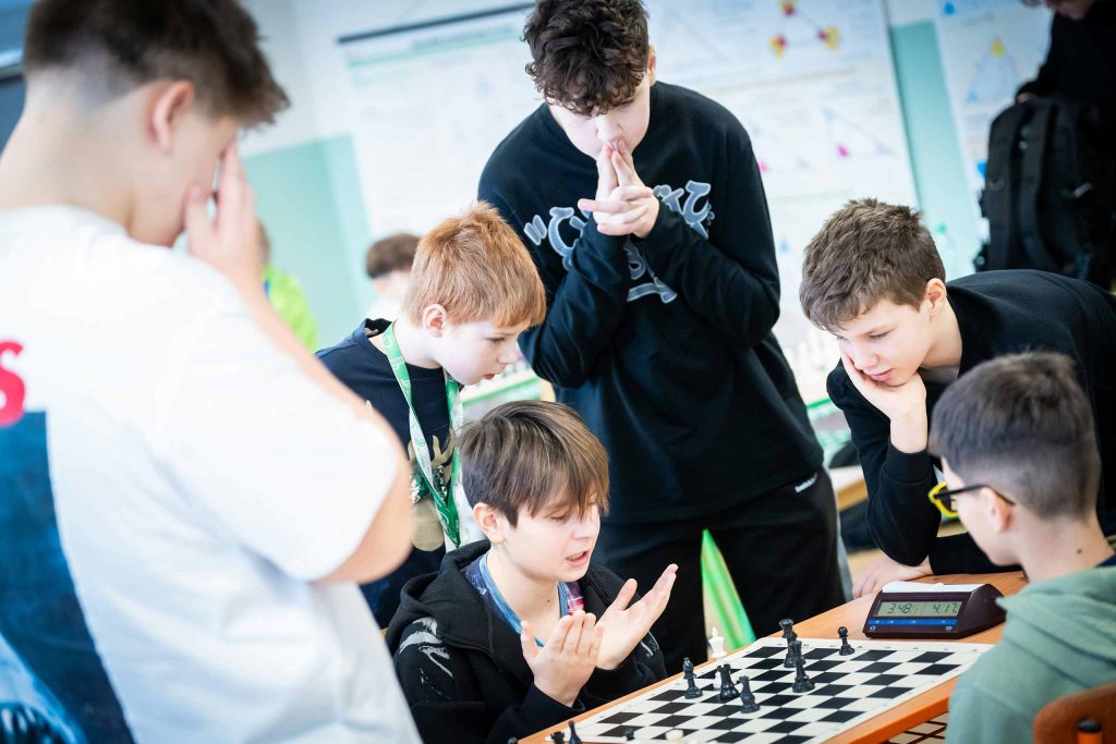 student gather around a chess board during a match