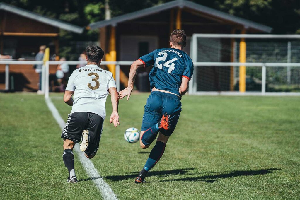 Boys soccer team kicking the ball towards the goal.